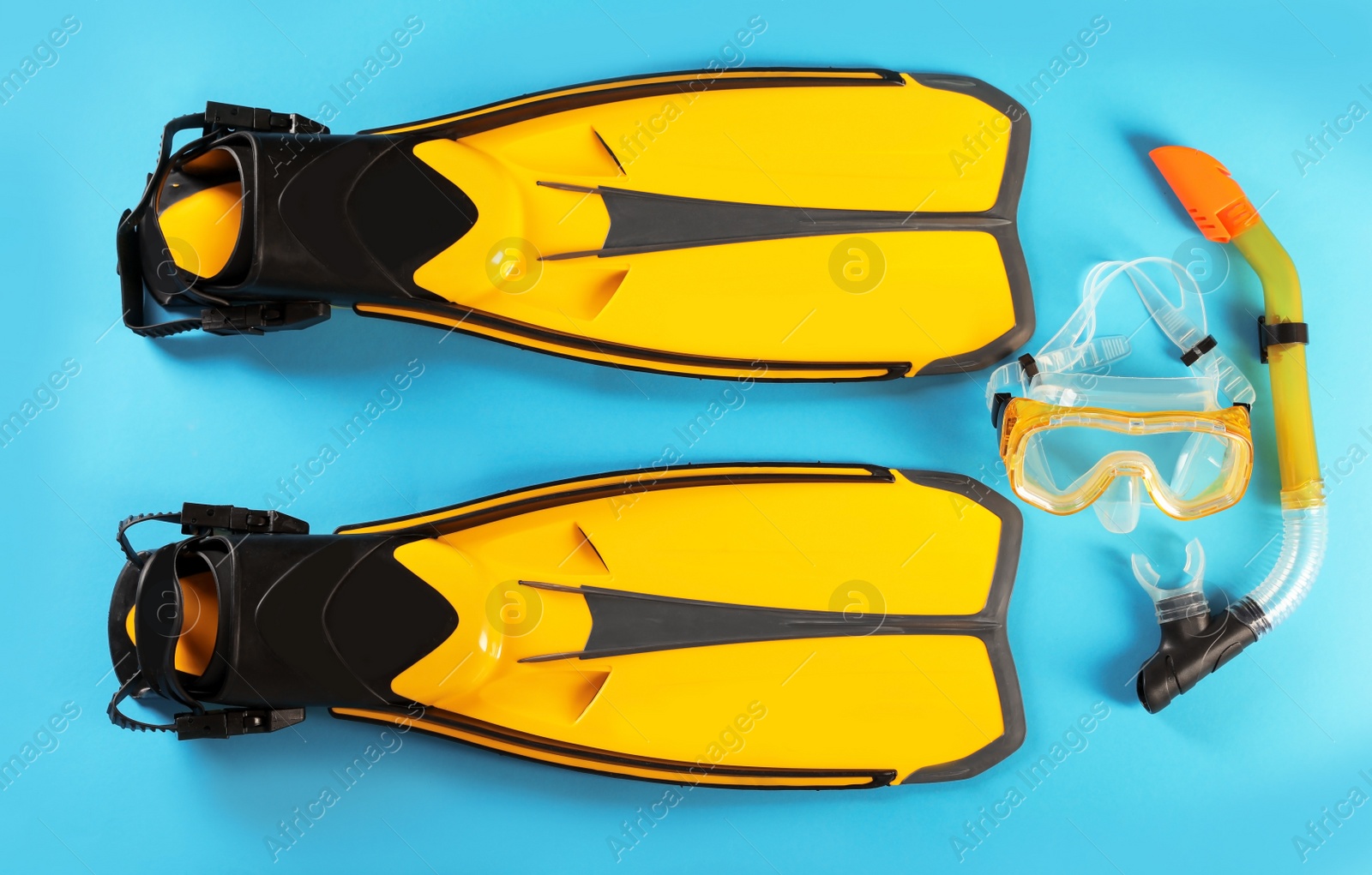 Photo of Pair of yellow flippers and diving mask on color background, top view
