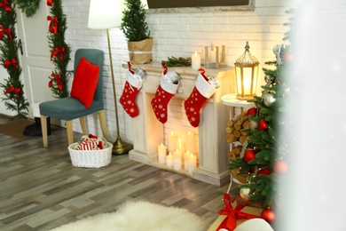 Stylish interior with beautiful Christmas tree and decorative fireplace