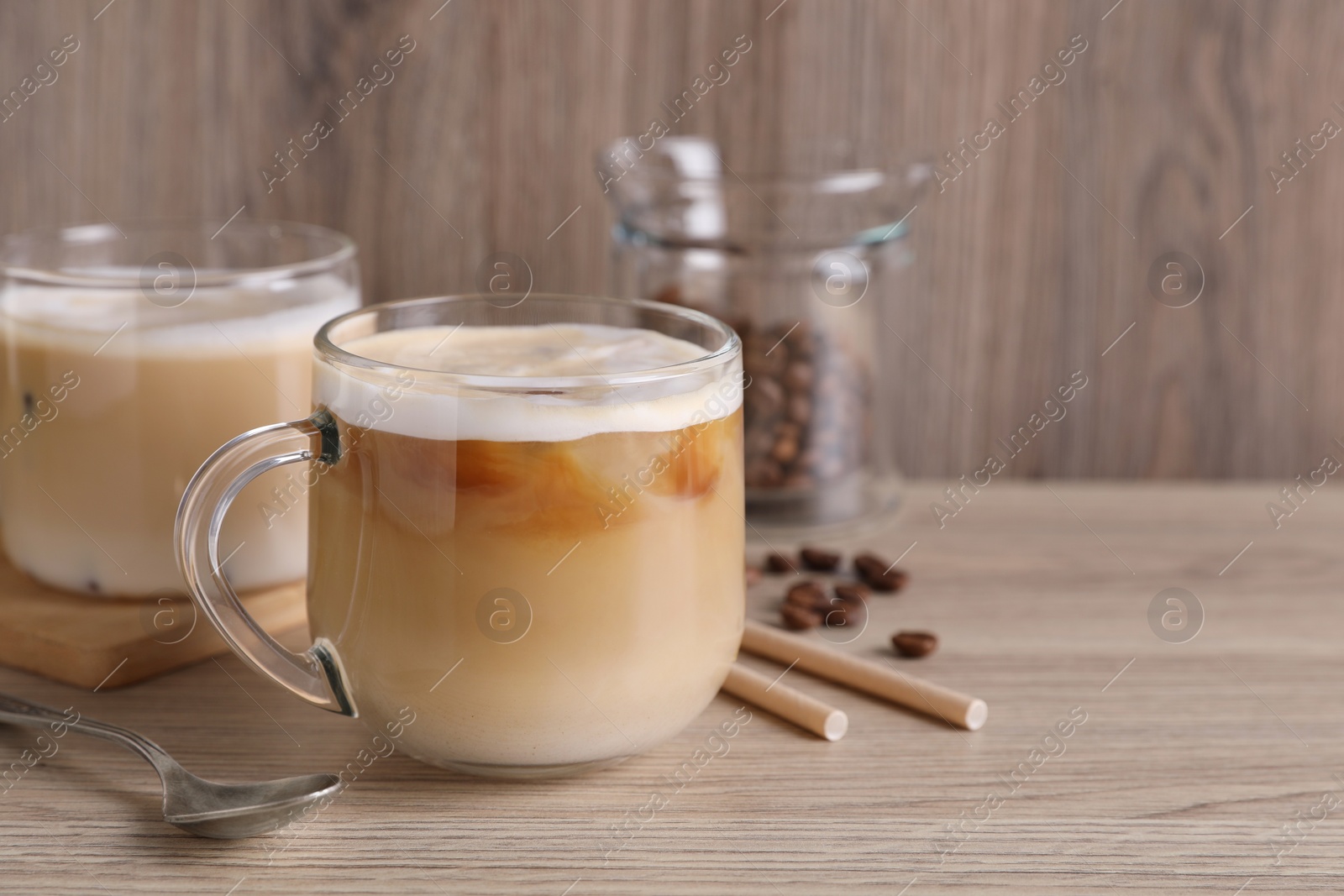 Photo of Fresh coffee, beans and straws on wooden table. Space for text