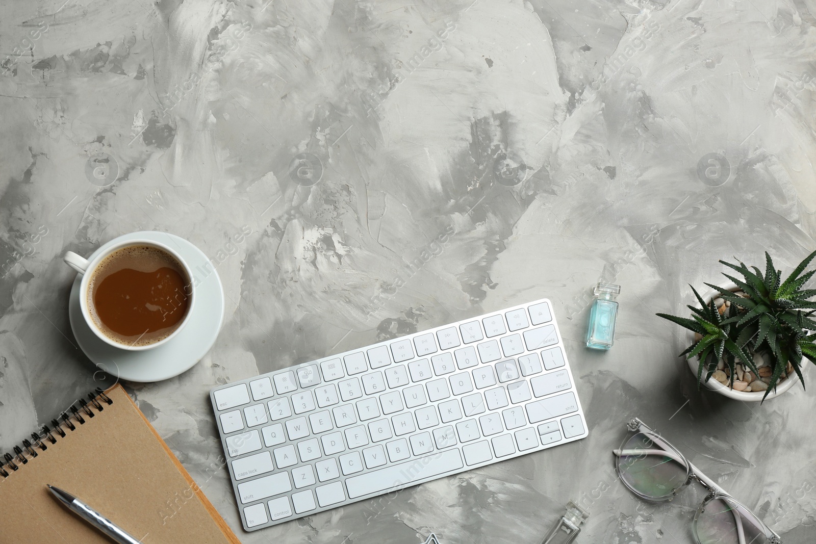 Photo of Blogger's workplace with keyboard, coffee and accessories on grey background, top view. Space for text