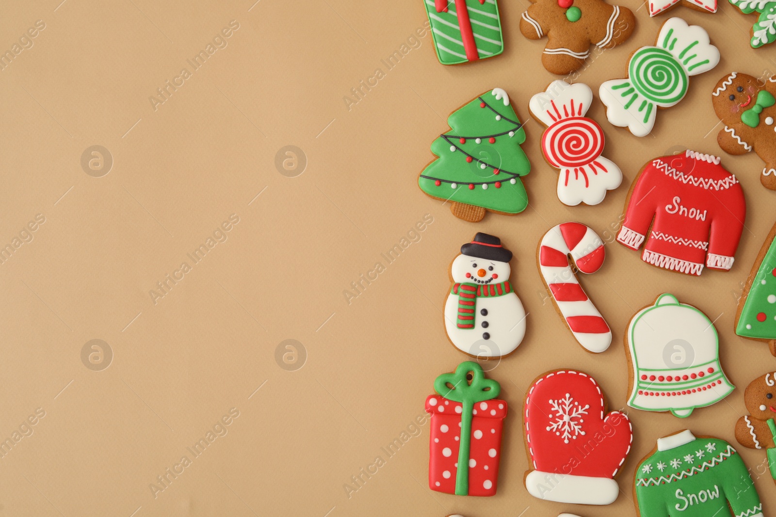 Photo of Different Christmas gingerbread cookies on brown background, flat lay. Space for text