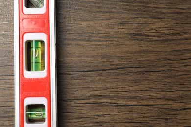 Photo of Building level on wooden table, top view. Space for text