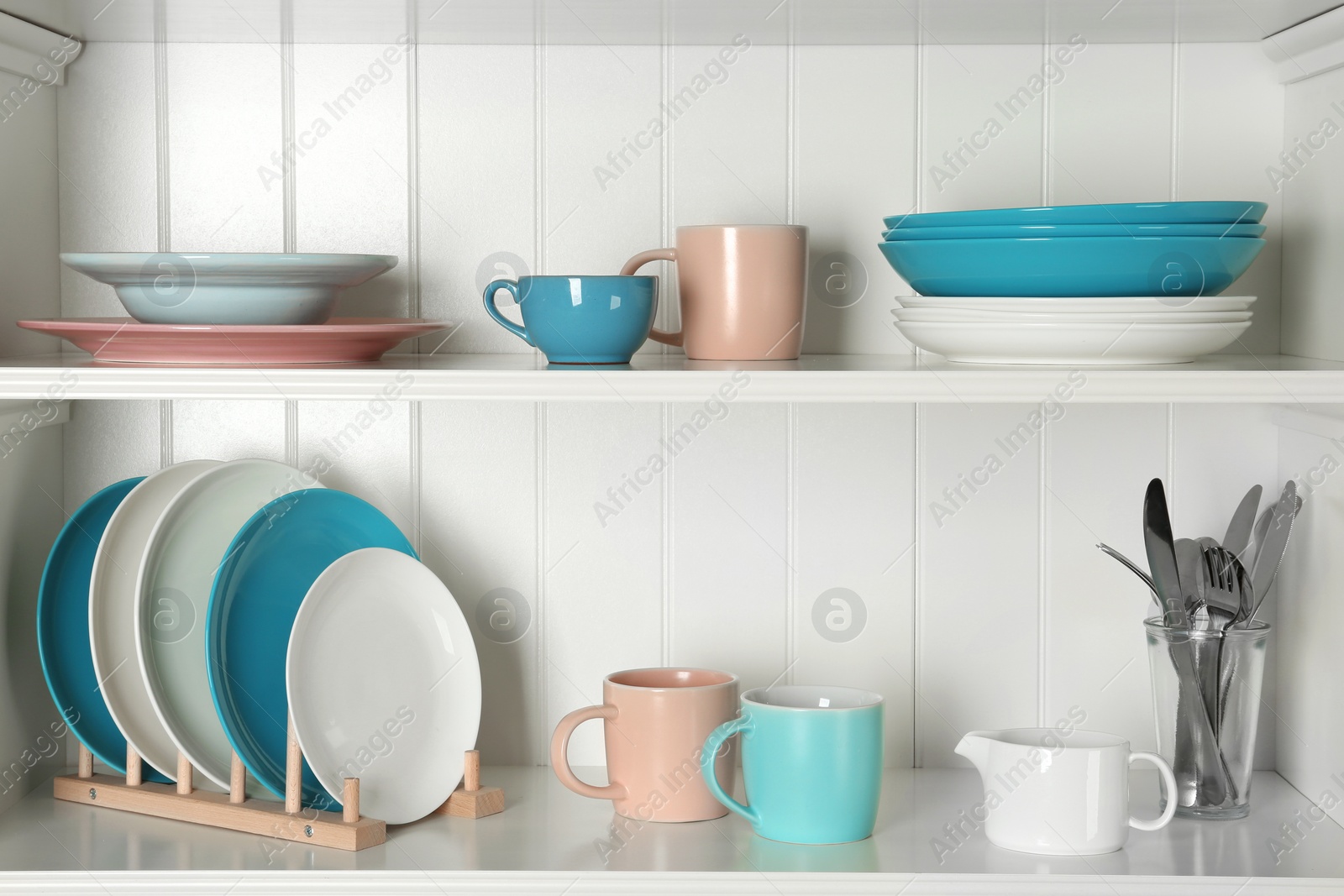 Photo of White shelving unit with set of dishware