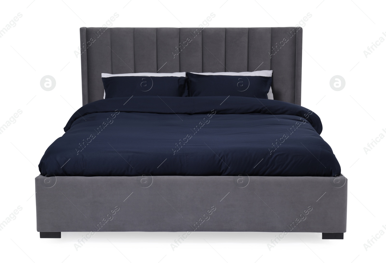 Photo of Comfortable gray bed with dark blue linens on white background