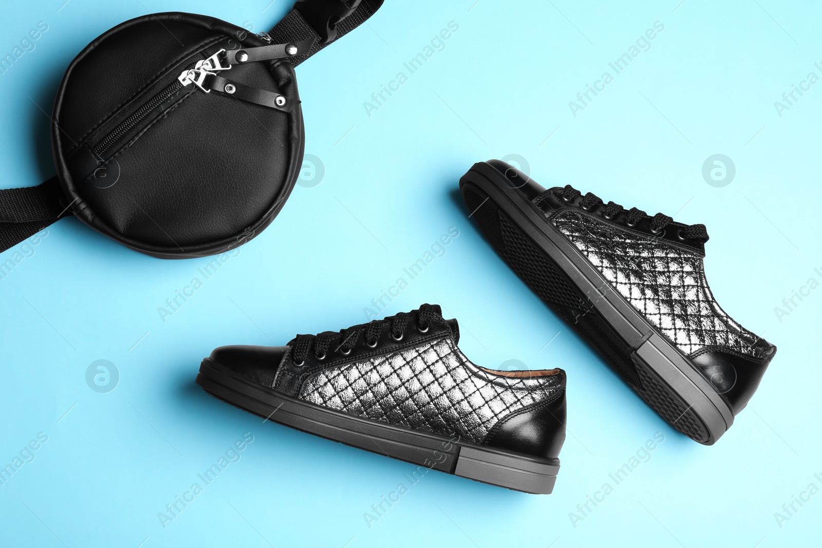 Photo of Flat lay composition of stylish shoes and bum bag on color background