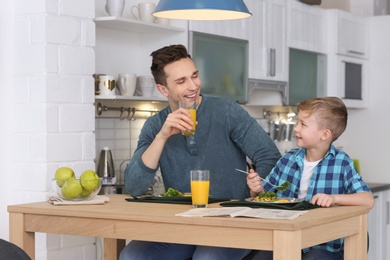 Dad and his son having breakfast in kitchen