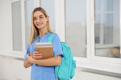 Portrait of young intern wearing uniform in university hall, space for text