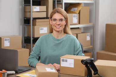 Seller with parcels and laptop in office. Online store