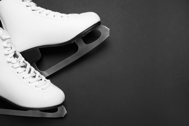 Photo of Pair of skates on black background, above view. Space for text