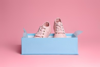 Photo of Pair of stylish canvas shoes in box on pink background