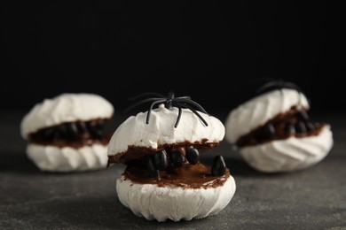 Photo of Delicious desserts decorated as monsters on grey table. Halloween treat