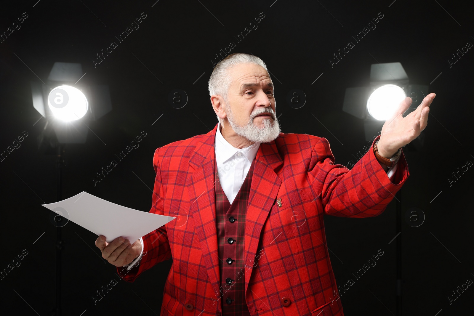 Photo of Senior actor with script performing on stage