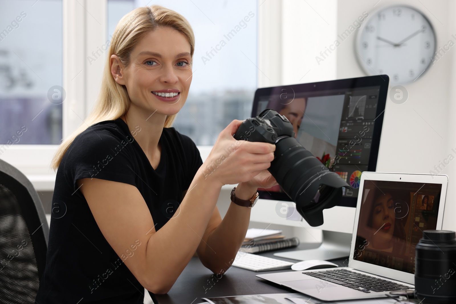 Photo of Professional photographer with digital camera at table in office