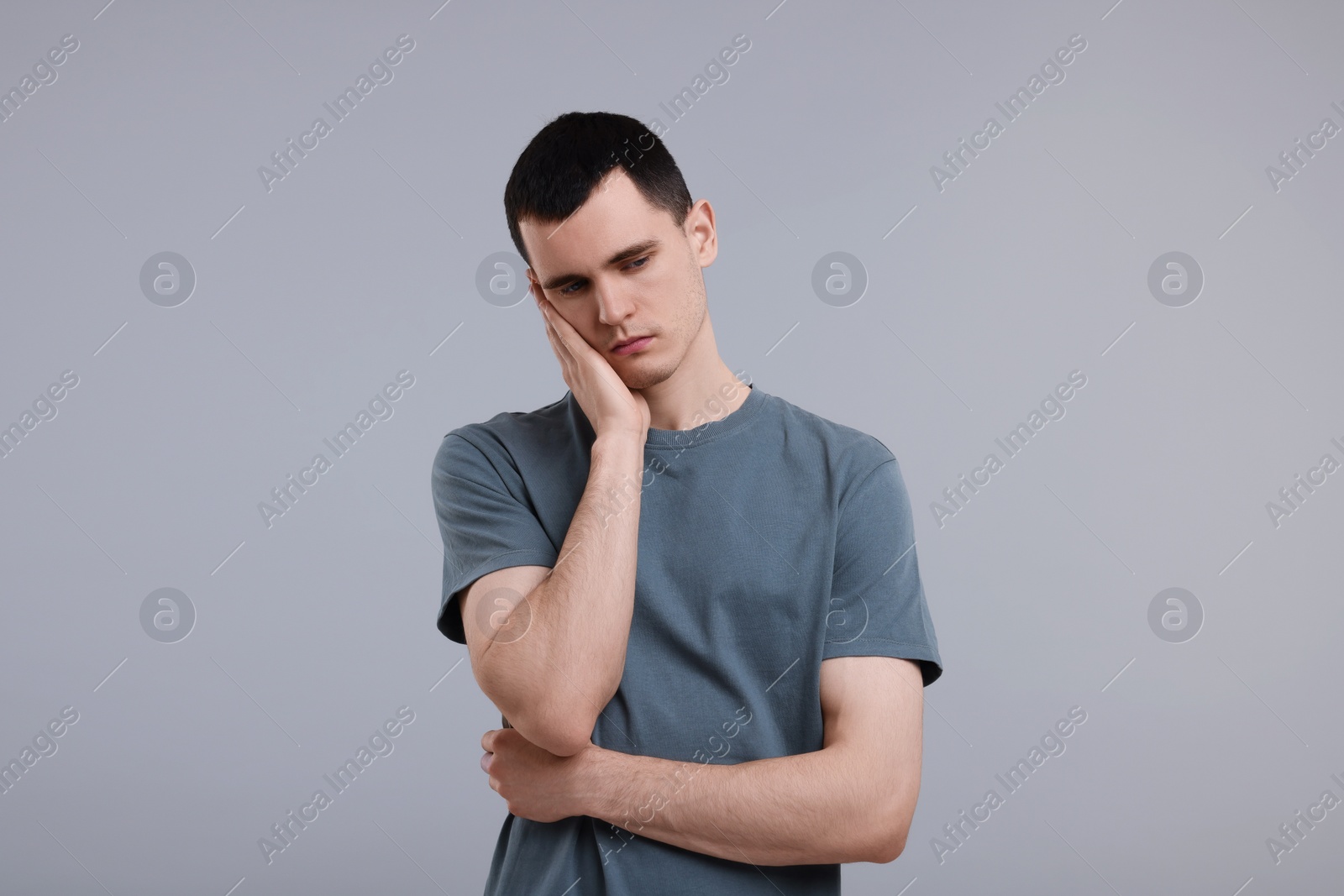 Photo of Portrait of sad man on grey background