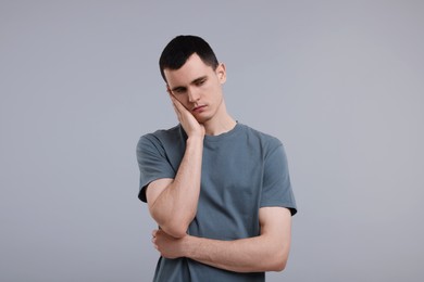 Portrait of sad man on grey background