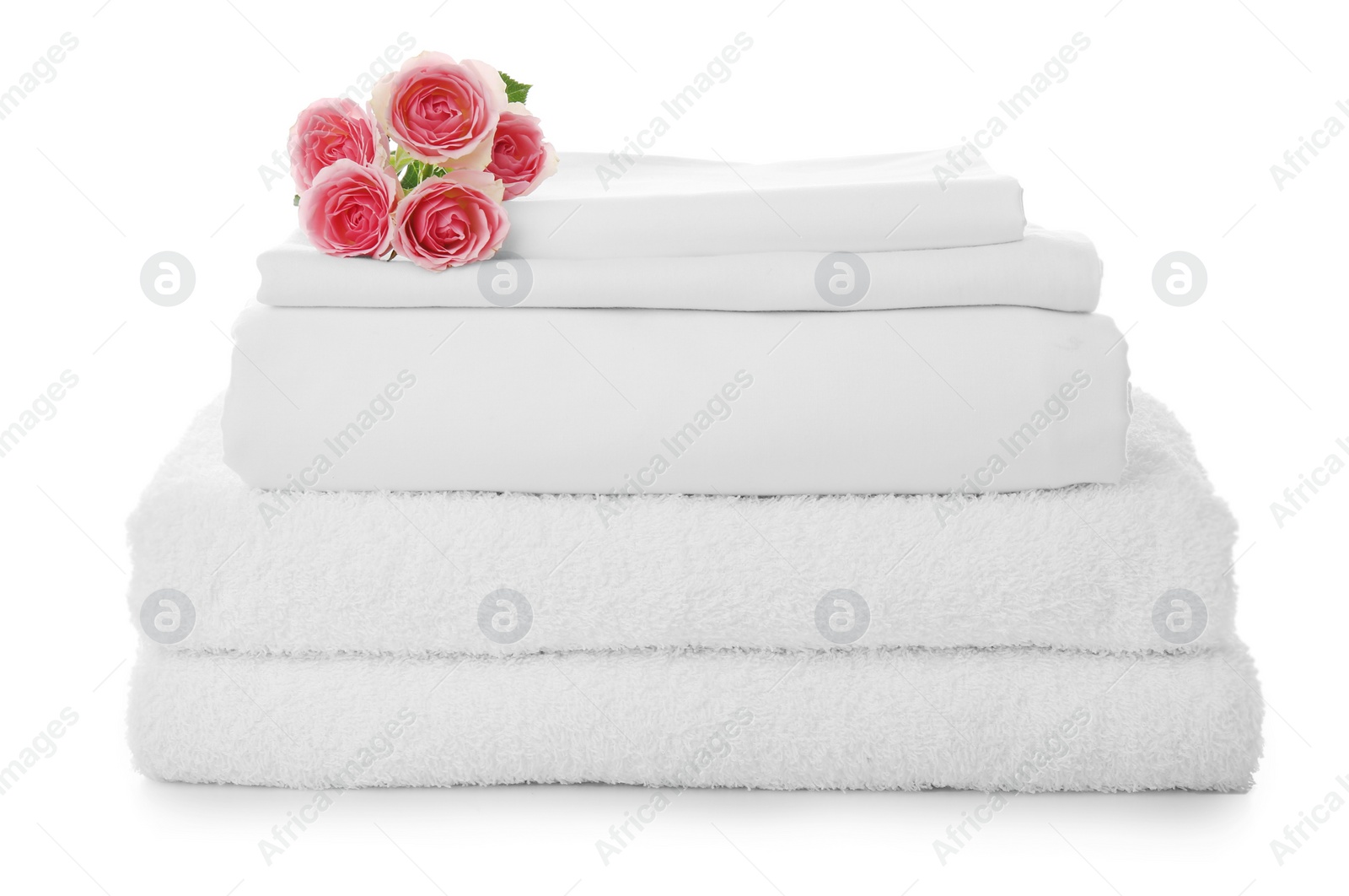 Photo of Stack of towels and bed sheets with roses on white background