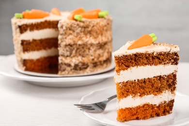 Sweet carrot cake with delicious cream on white wooden table