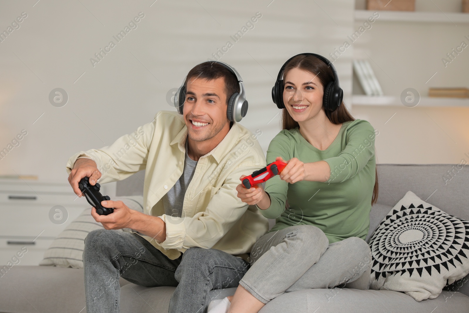 Photo of Couple playing video games with controllers at home