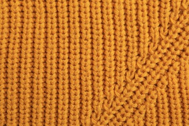 Beautiful orange knitted fabric as background, top view