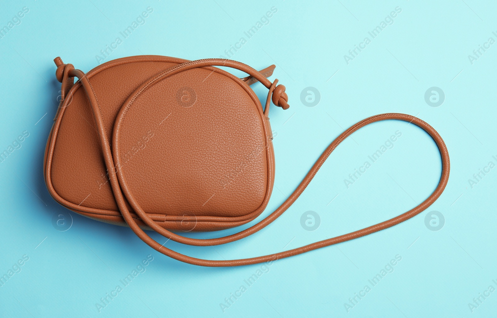 Photo of Stylish woman's bag on light blue background, top view