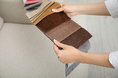 Photo of Woman choosing fabric among colorful samples indoors, closeup