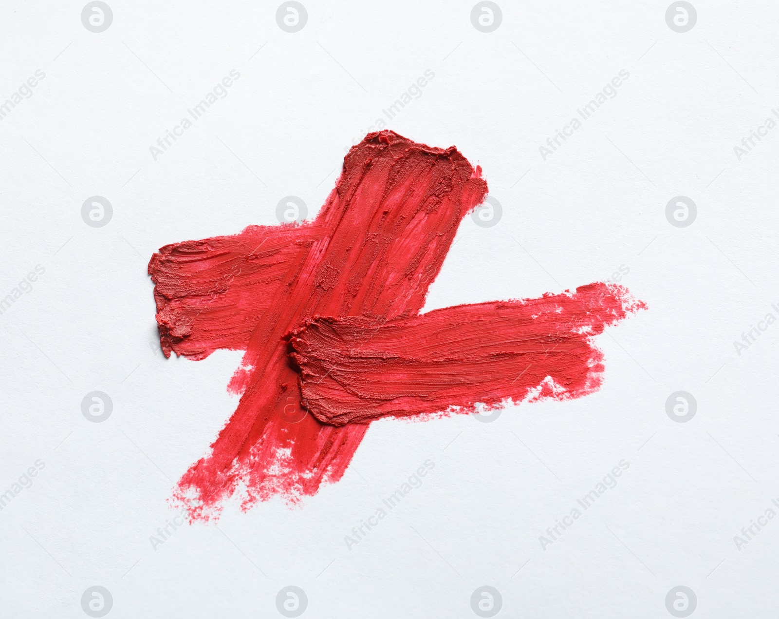 Photo of Red lipstick smears on white background, top view