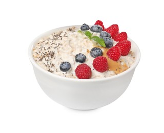 Photo of Tasty boiled oatmeal with berries, chia seeds and peanut butter in bowl isolated on white