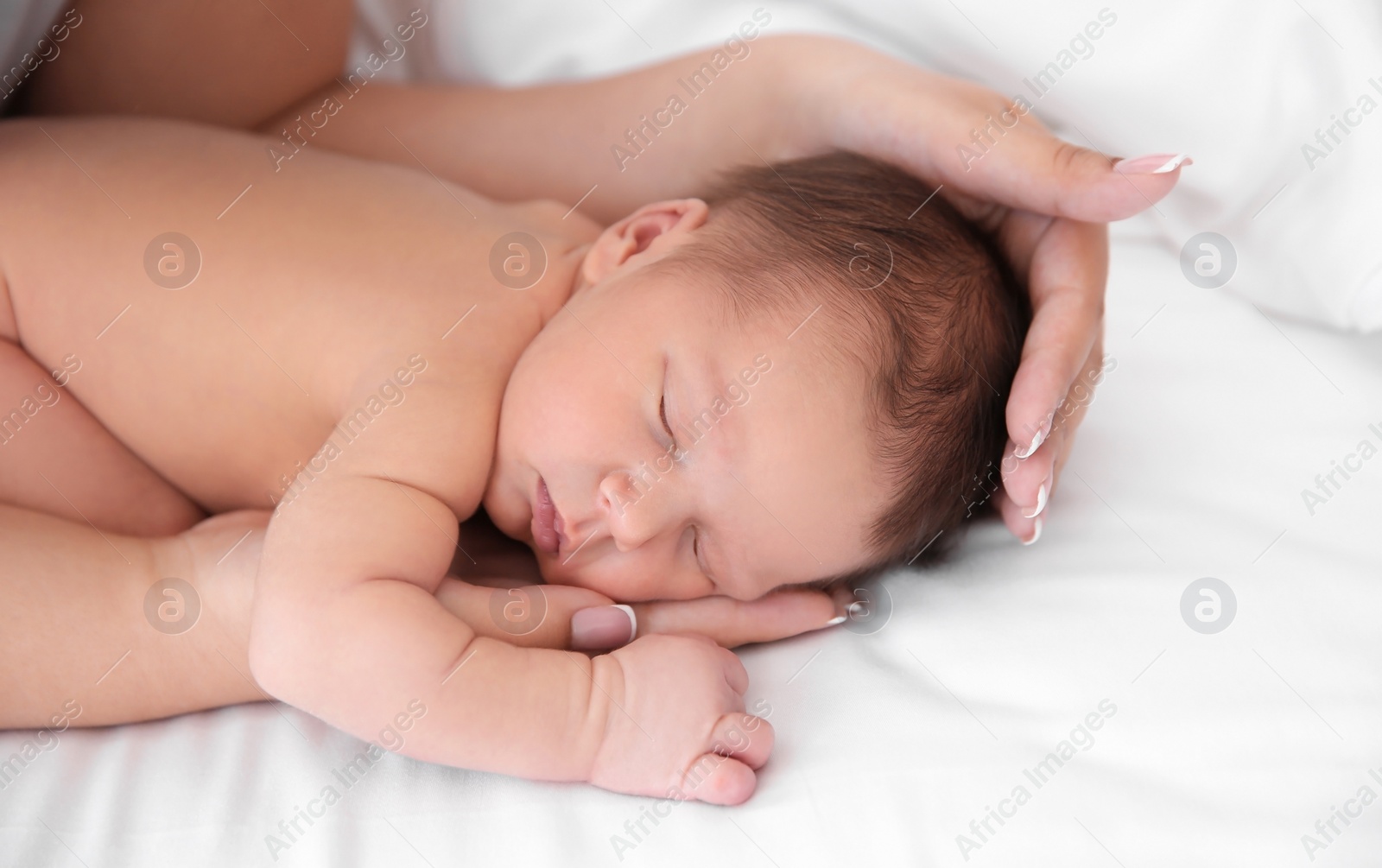 Photo of Mother with little newborn baby on bed