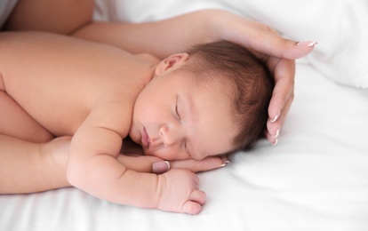 Photo of Mother with little newborn baby on bed