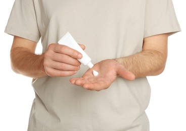 Man applying cream onto hand against white background, closeup