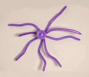 Spider figure made of modelling balloon on color background, top view