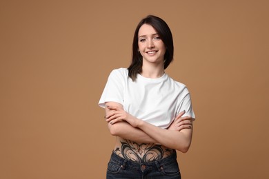 Photo of Portrait of smiling tattooed woman on beige background