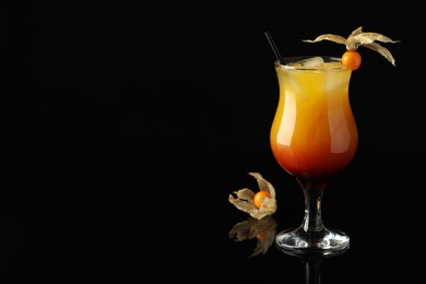 Photo of Tasty cocktail decorated with physalis fruit on black background. Space for text