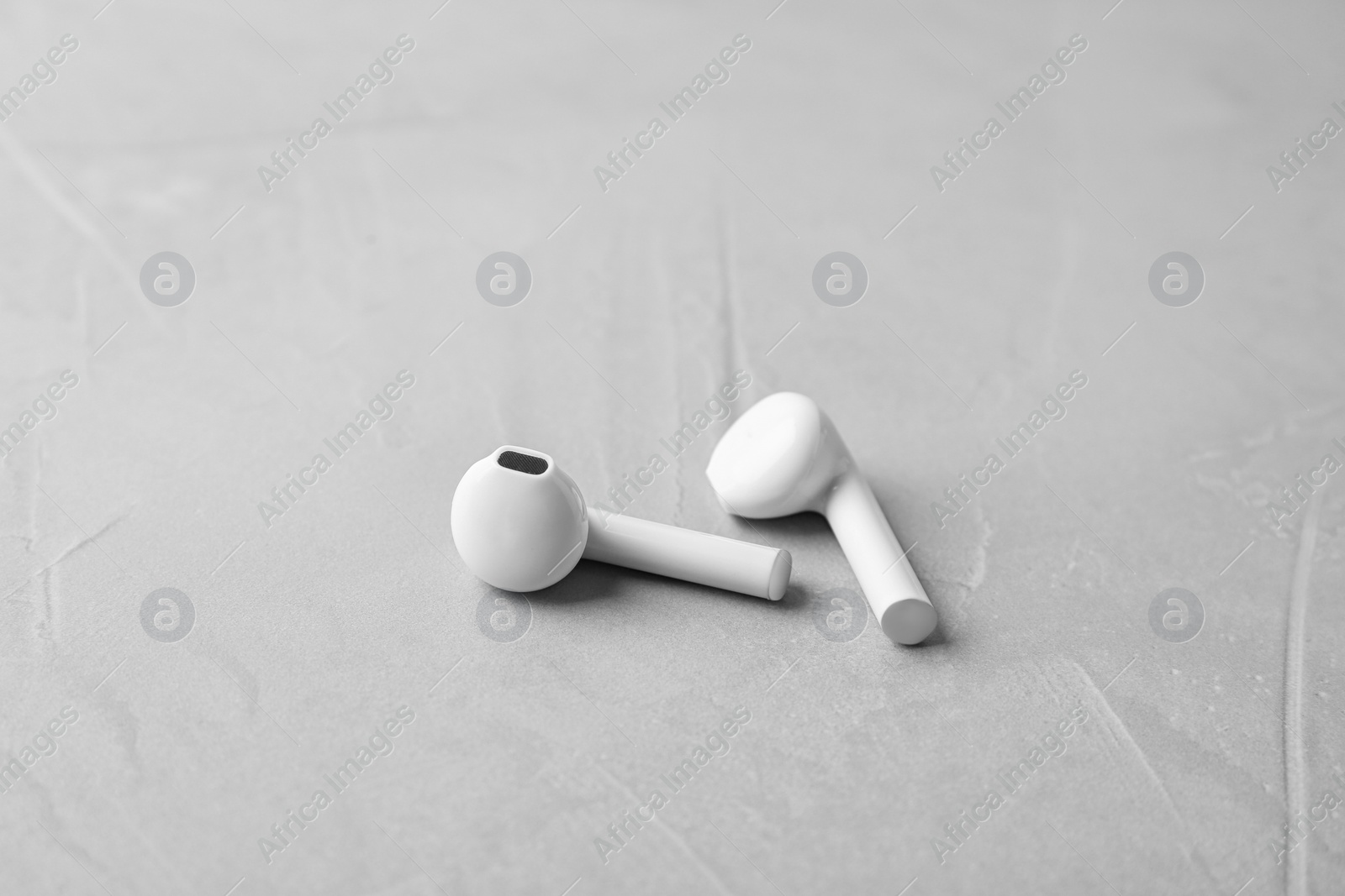 Photo of Wireless earphones on light grey stone table