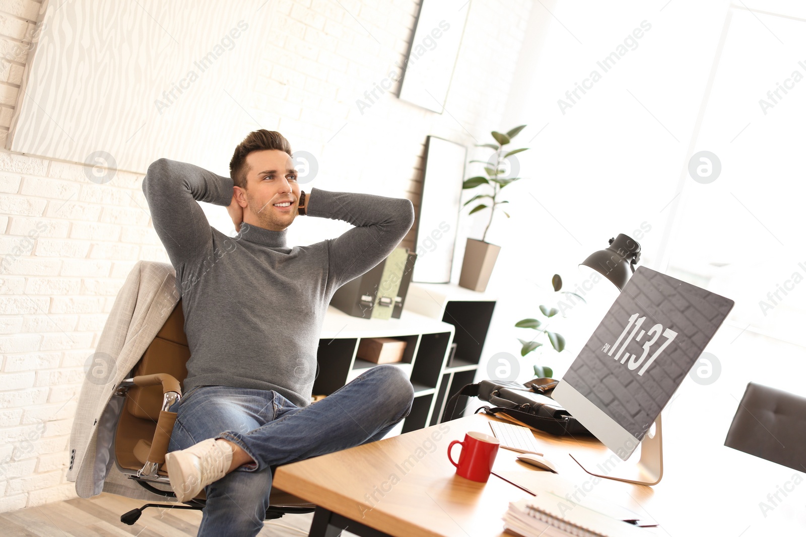 Photo of Young man relaxing at table in office during break