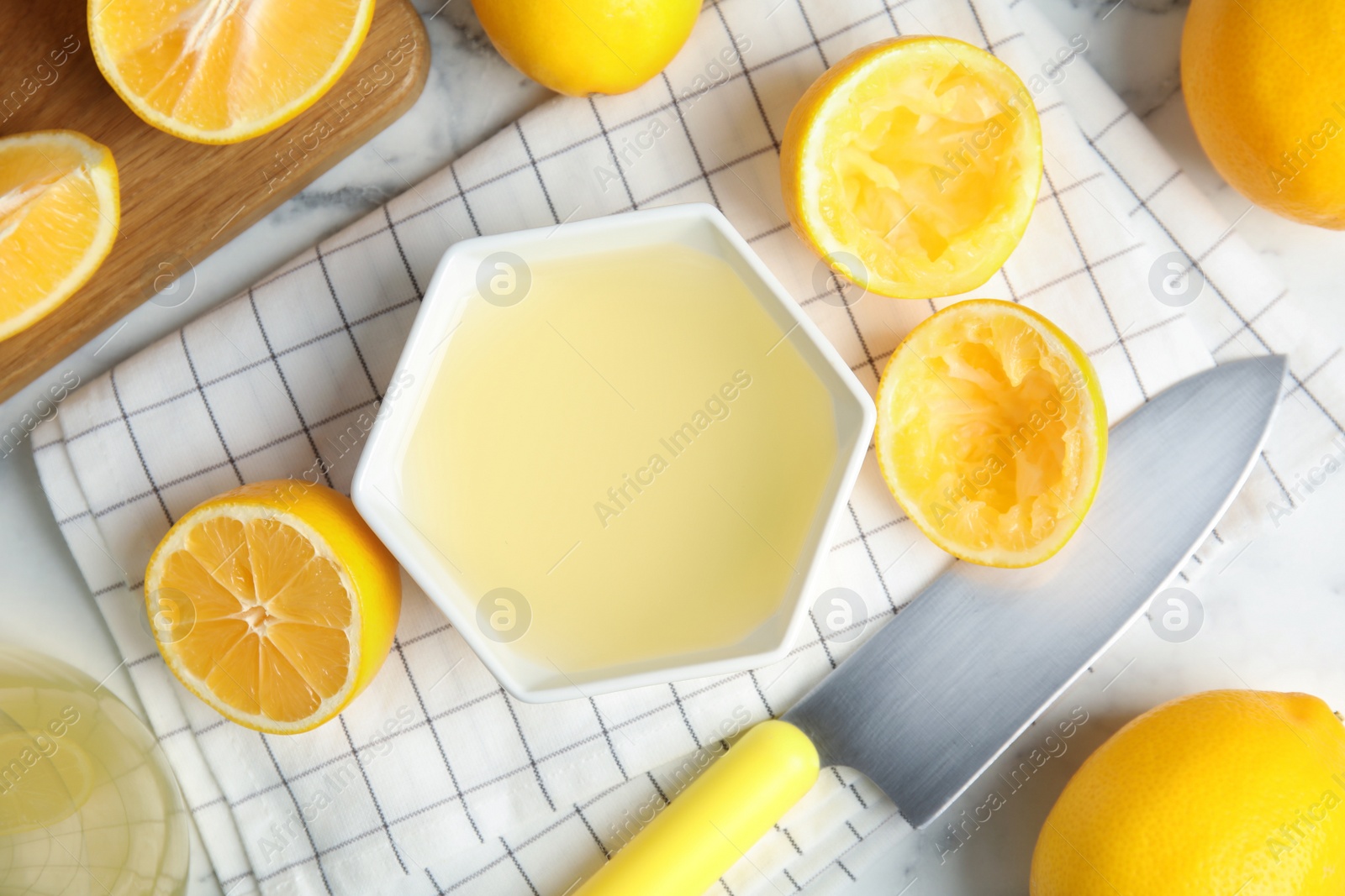 Photo of Freshly squeezed lemon juice on light table, flat lay