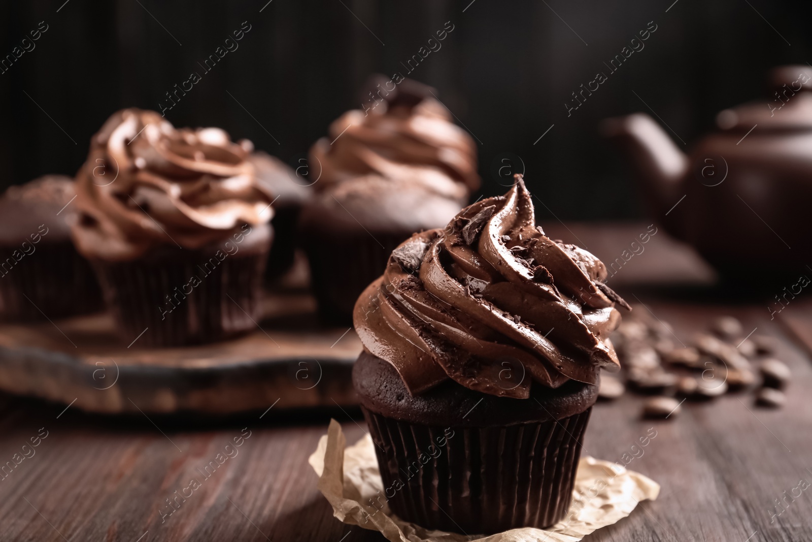 Photo of Delicious cupcake decorated with cream on wooden table, closeup