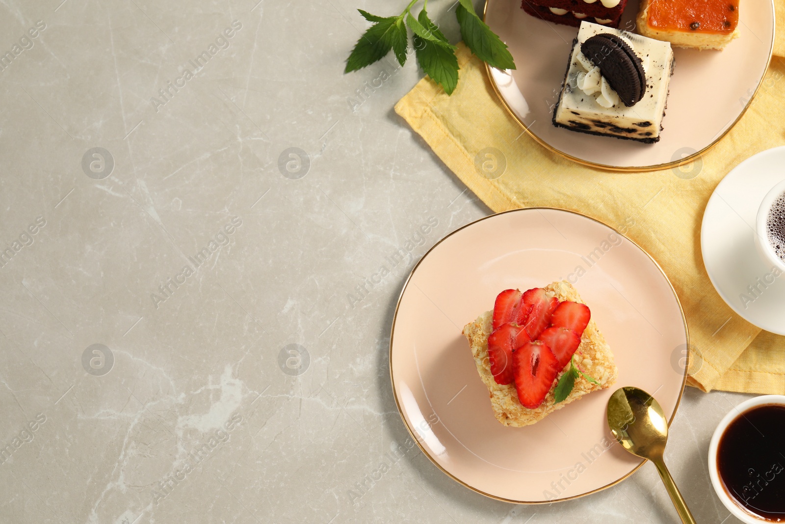 Photo of Different tasty cakes on light grey marble table, flat lay. Space for text