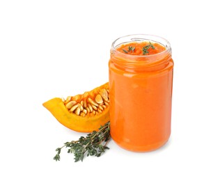 Jar of pumpkin jam, fresh pumpkin and thyme on white background
