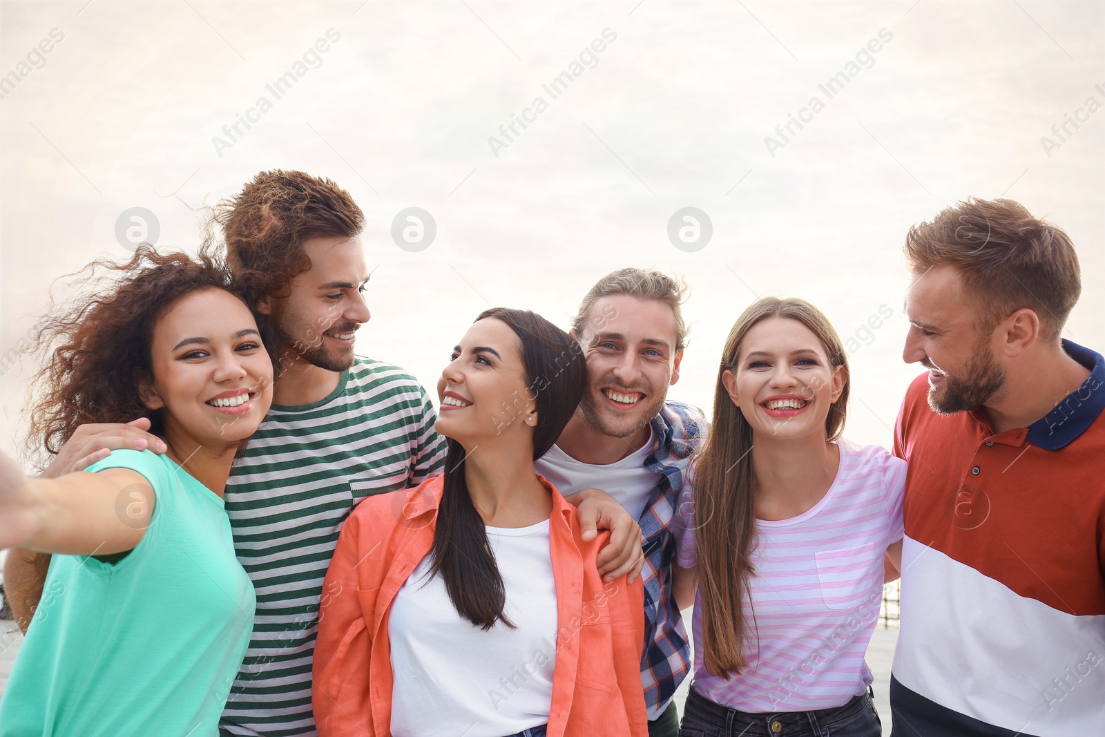 Photo of Happy young people taking selfie outdoors on sunny day