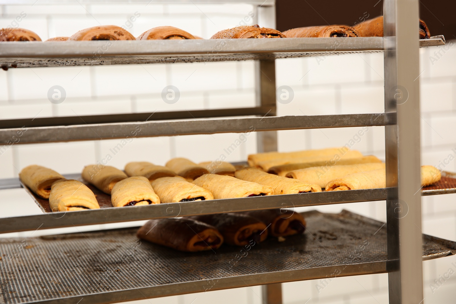 Photo of Rack with fresh pastries in bakery workshop