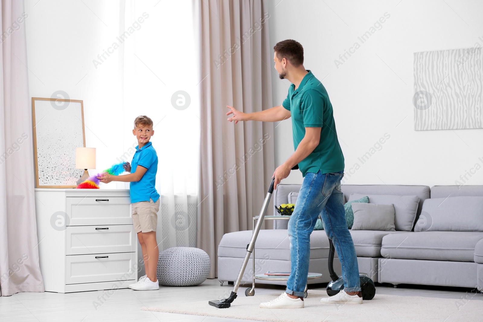 Photo of Dad and son cleaning living room together