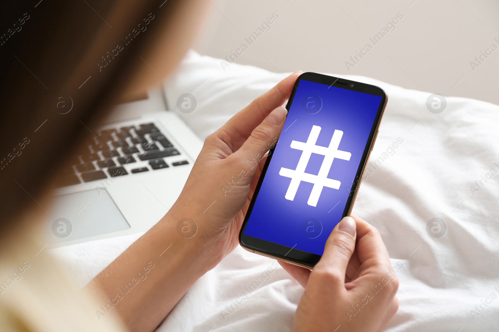 Image of Woman using modern smartphone with hashtag symbol on screen, closeup