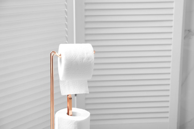 Holder with toilet paper rolls in bathroom