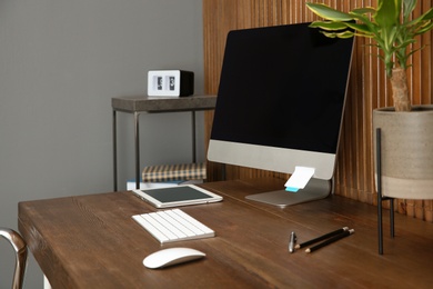 Stylish workplace with modern computer near wooden wall. Space for text