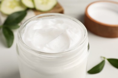 Photo of Glass jar of face cream on white table, closeup