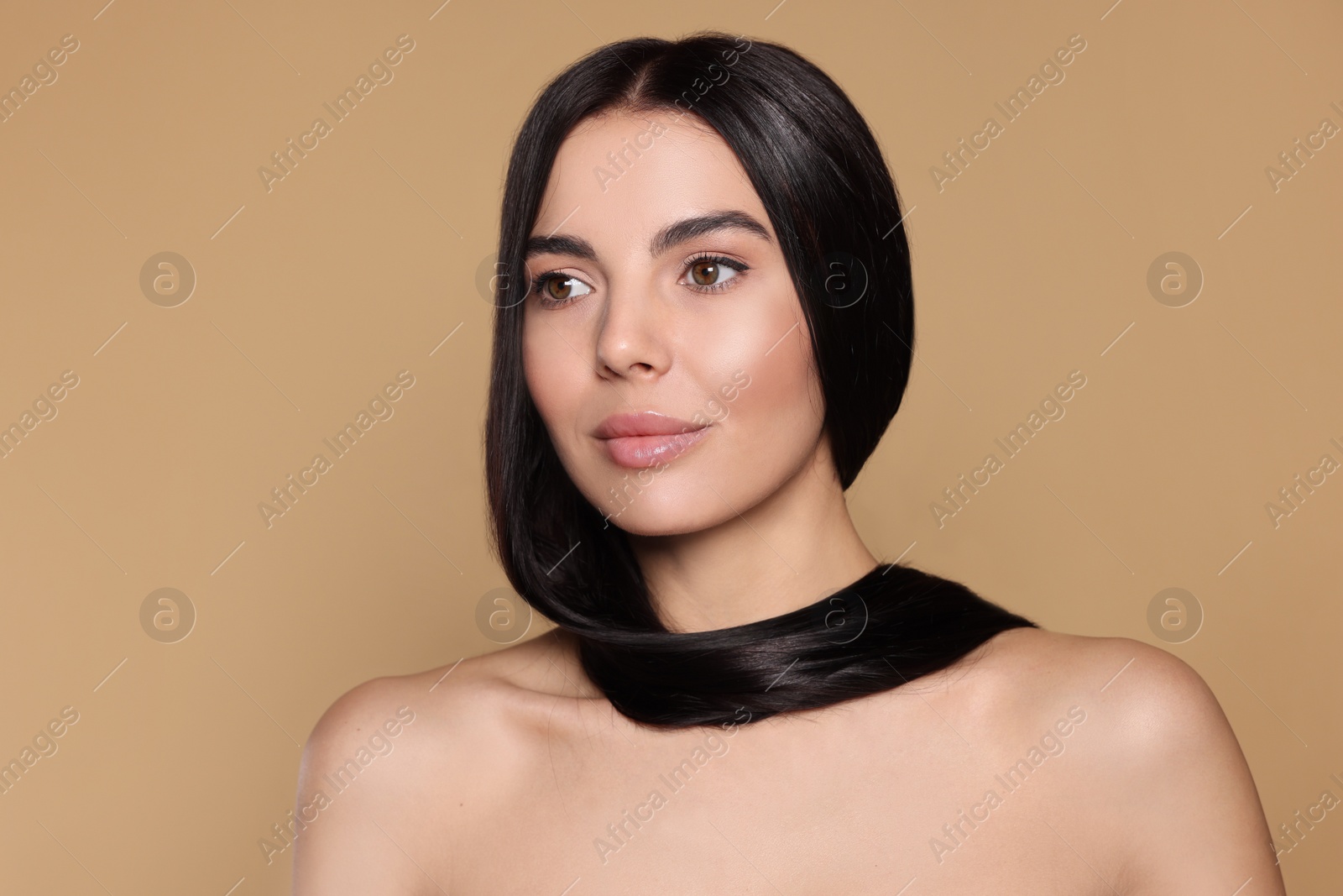 Photo of Portrait of beautiful young woman with healthy strong hair on beige background