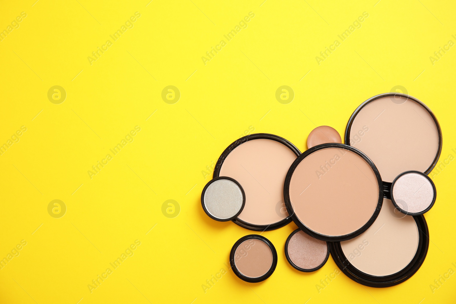 Photo of Flat lay composition with various makeup face powders on color background. Space for text