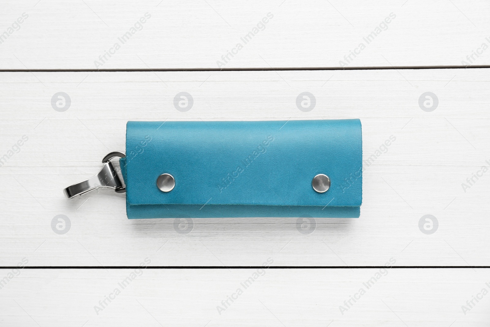 Photo of Stylish leather keys holder on white wooden table, top view