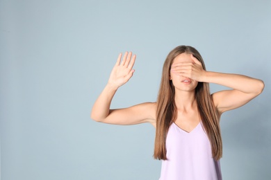 Photo of Young woman being blinded on grey background, space for text